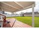 Covered deck with view of a well-maintained lawn, a white fence, and a storage shed, perfect for outdoor enjoyment at 2286 Sunny St, Kissimmee, FL 34741