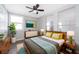 Bright bedroom with a wooden bed frame, colorful pillows, stylish lamps, and a large plant, creating a relaxing space at 2286 Sunny St, Kissimmee, FL 34741