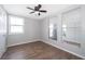 Clean, empty bedroom featuring wood floors, a ceiling fan, and large mirrors to enhance the room's sense of space at 2286 Sunny St, Kissimmee, FL 34741