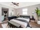 Modern bedroom with a gray bed, stylish decor, and a ceiling fan, creating a cozy and inviting atmosphere at 2286 Sunny St, Kissimmee, FL 34741