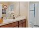 Bathroom with double sinks, brown cabinets and a shower with a blue-trimmed curtain at 2711 Wadeview Loop, St Cloud, FL 34769