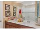 Bathroom featuring double vanity, a neutral color palette, framed pictures and a glass-enclosed shower at 2711 Wadeview Loop, St Cloud, FL 34769