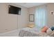 Minimalist bedroom with television, mirror, light blue curtain, and tile flooring at 2711 Wadeview Loop, St Cloud, FL 34769