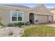 Charming home featuring a manicured lawn, decorative garden, and a two-car garage with a brick-paved driveway at 2711 Wadeview Loop, St Cloud, FL 34769
