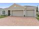 Charming home featuring a two-car garage with a brick-paved driveway and manicured landscaping at 2711 Wadeview Loop, St Cloud, FL 34769