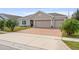 Charming home with a two-car garage and a brick-paved driveway complemented by lush landscaping at 2711 Wadeview Loop, St Cloud, FL 34769