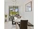 Dining room featuring modern lighting with view of screened lanai and backyard at 2800 Cello Ln, Kissimmee, FL 34741