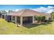 Stunning backyard view of home featuring a screened-in lanai, manicured lawn, and lush landscaping at 3438 Fallbrook Dr, Kissimmee, FL 34759