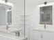 Bright bathroom showcasing double sinks, marble countertops, modern fixtures, and large mirrors at 411 Boxwood Dr, Davenport, FL 33837