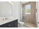 Beautiful bathroom showcasing a dark vanity, marble countertop, stylish fixtures, and glass shower door at 411 Boxwood Dr, Davenport, FL 33837