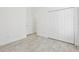Bright bedroom features light wood floors, white walls, and a closet with double doors at 411 Boxwood Dr, Davenport, FL 33837