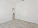 Bright bedroom with light wood floors, white walls, and doorway leading to other rooms in the house at 411 Boxwood Dr, Davenport, FL 33837