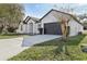 Attractive single-story home featuring a dark roof, white exterior, long driveway, and a two-car garage at 411 Boxwood Dr, Davenport, FL 33837