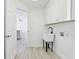 Clean laundry room with white cabinets, utility sink, and neutral flooring at 411 Boxwood Dr, Davenport, FL 33837