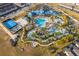 Aerial view of the resort-style community pool with lazy river, water slides, splash pad, cabanas, and blue-roofed clubhouse at 4138 Lana Ave, Davenport, FL 33897