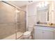 Well-lit bathroom featuring a tiled shower with glass doors, modern vanity, and updated fixtures at 4138 Lana Ave, Davenport, FL 33897