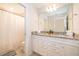 Well-lit bathroom featuring a double sink vanity and a shower with a curtain at 4138 Lana Ave, Davenport, FL 33897