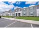 Row of gray townhomes with blue shutters, green lawns, and parking spaces at 4138 Lana Ave, Davenport, FL 33897