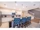 Modern kitchen featuring white cabinetry, granite countertops, stainless steel appliances, and stylish barstool seating at 4138 Lana Ave, Davenport, FL 33897