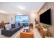 Bright living room with a comfortable couch, stylish decor, a large tv, and sliding doors to the pool area at 4138 Lana Ave, Davenport, FL 33897