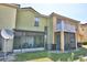 Townhome backyard featuring a screened-in porch, balcony, and lawn at 500 Monroe Cir, Davenport, FL 33896