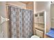 Full bathroom features patterned shower curtain and storage cabinet above toilet at 500 Monroe Cir, Davenport, FL 33896