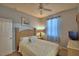 Cozy bedroom with a ceiling fan, plush bedding, and light-filled window at 500 Monroe Cir, Davenport, FL 33896