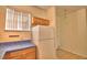 Compact kitchen with wooden cabinets, white appliances, and adjacent eating area at 500 Monroe Cir, Davenport, FL 33896