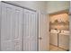 Hallway view into the laundry closet with washer, dryer, and storage shelves at 500 Monroe Cir, Davenport, FL 33896