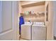 Functional laundry room with standard washer and dryer, plus storage shelving at 500 Monroe Cir, Davenport, FL 33896