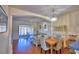 Open-concept living and dining area with a chandelier, ceiling fan, and sliding glass doors to the patio at 500 Monroe Cir, Davenport, FL 33896