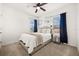 Comfortable bedroom features neutral tones, ceiling fan, carpet floors, and natural light from two windows at 5117 Oakbourne Ave, Davenport, FL 33837
