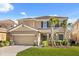 Charming two-story home featuring a tile roof, well-manicured lawn and two-car garage at 5117 Oakbourne Ave, Davenport, FL 33837