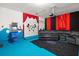 Finished basement game room features blue flooring, projector screen, arcade game and comfortable sectional seating at 5117 Oakbourne Ave, Davenport, FL 33837