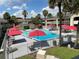 A stunning pool is surrounded by a white fence and several chairs for lounging with bright red umbrellas providing shade at 5245 W Irlo Bronson Memorial Hwy # 192, Kissimmee, FL 34746