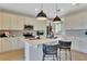 Modern kitchen with a large island, white cabinets, stainless steel appliances, and pendant lighting at 5457 Catmint Dr, Lake Hamilton, FL 33851