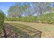 View of the backyard and landscaped greenery with mature trees, offering privacy and natural beauty at 5512 Solterra Cir, Davenport, FL 33837