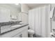 A bathroom featuring tile flooring, a granite countertop, a large mirror, and a shower with a white shower curtain at 5512 Solterra Cir, Davenport, FL 33837