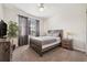 This bedroom features carpet, a ceiling fan, a bed with gray bedding, curtains, and a dark brown nightstand at 5512 Solterra Cir, Davenport, FL 33837