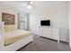 This bedroom features a painting, carpet, a bed with yellow bedding, a ceiling fan, and a white dresser at 5512 Solterra Cir, Davenport, FL 33837