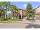 Charming two-story home featuring tropical landscaping, a brick driveway, and an attached garage at 5512 Solterra Cir, Davenport, FL 33837