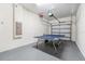 This is a garage with a ping pong table, a white painted wall, and a white garage door at 5512 Solterra Cir, Davenport, FL 33837