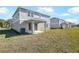 Backyard view of a new home, highlighting the covered patio area and grassy lawn at 570 Summit River Dr, Apopka, FL 32712