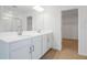 Bathroom featuring double sink vanity, wood look floors, and walk-in closet with shelving for added storage at 570 Summit River Dr, Apopka, FL 32712