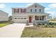 Two-story home with stone accents, red shutters, front porch, and attached two-car garage at 570 Summit River Dr, Apopka, FL 32712