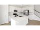 Bright, white kitchen features stainless steel appliances, an island with a sink, and tile floors at 570 Summit River Dr, Apopka, FL 32712