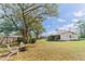 Large backyard featuring a fire pit, mature trees, and views of the house and surrounding greenery at 6449 Eve St, St Cloud, FL 34771