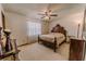 Bedroom with a classic bed frame, ceiling fan, and natural light from the window at 6449 Eve St, St Cloud, FL 34771