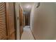 Hallway with wood doors and trim, carpet flooring, and access to various rooms at 6449 Eve St, St Cloud, FL 34771