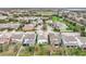 An aerial view of a suburban neighborhood with well-maintained homes, green lawns, and a pond in the distance at 6974 Trellis Vine Loop, Windermere, FL 34786